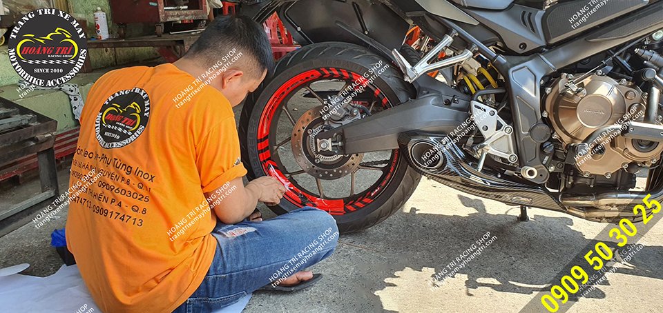 Nhân viên đang thi công dán decal phản quang bánh mâm cho CB650R