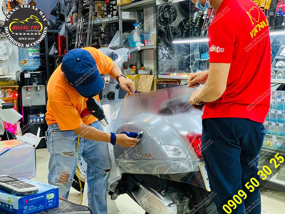 Construction worker applying PPF glue for Vespa GTS