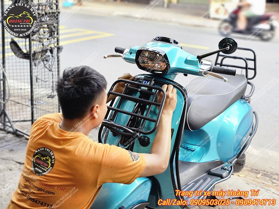 Nhân viên đang lắp đặt baga trước cho xe Vespa Sprint