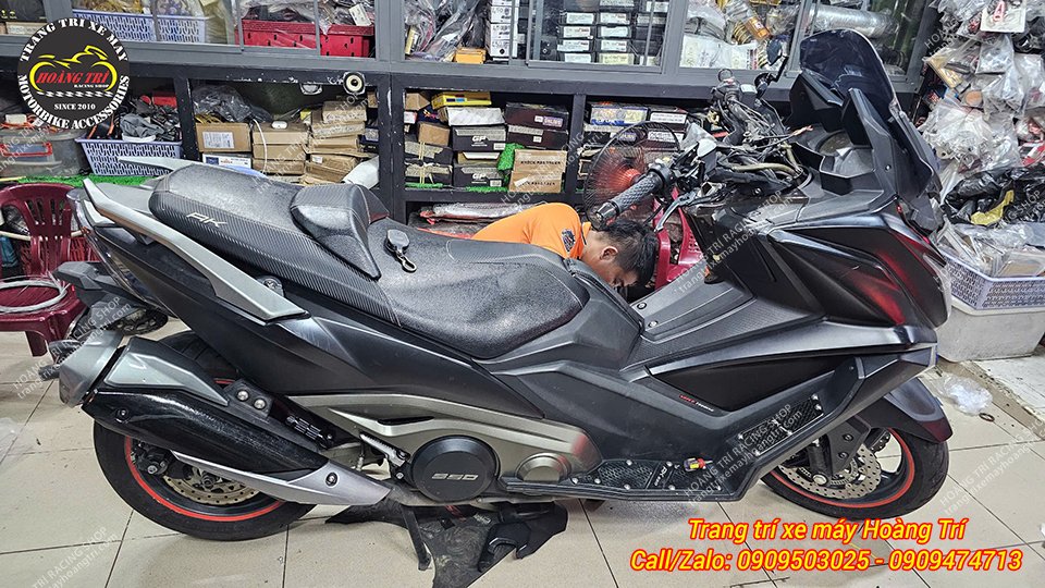 Nhân viên đang lắp đặt thêm đèn trợ sáng cho xe Kymco AK 550 Premium