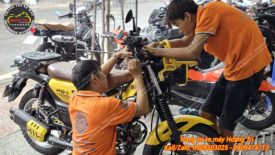 Nhân viên đang tiến hành cố định màn hình trên ghi đông xe