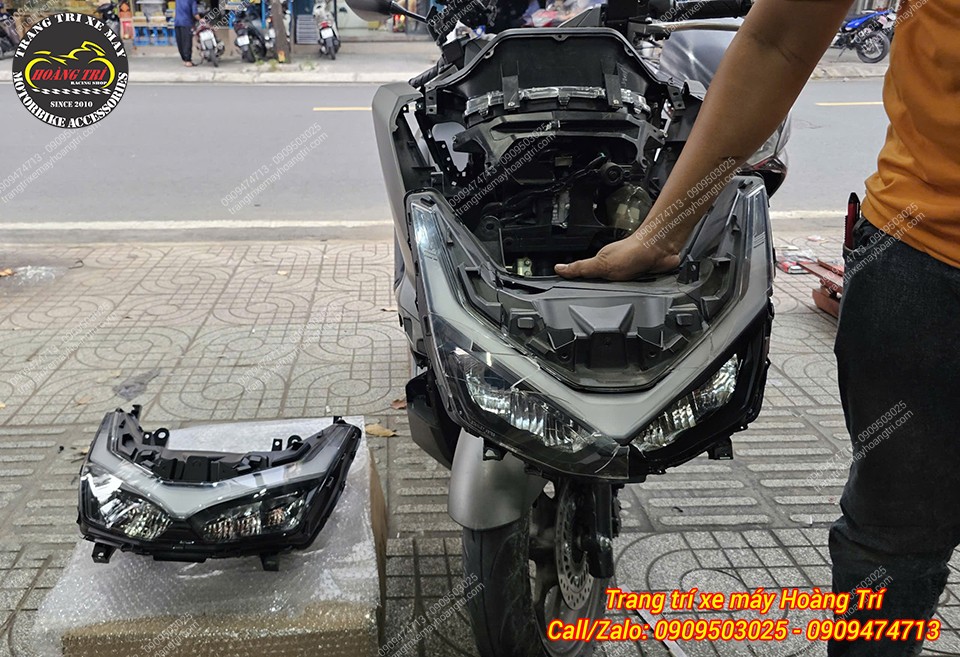 Cụm đèn cũ đã được tháo ra, trên tay là chi tiết hư hỏng chuẩn bị được thay mới