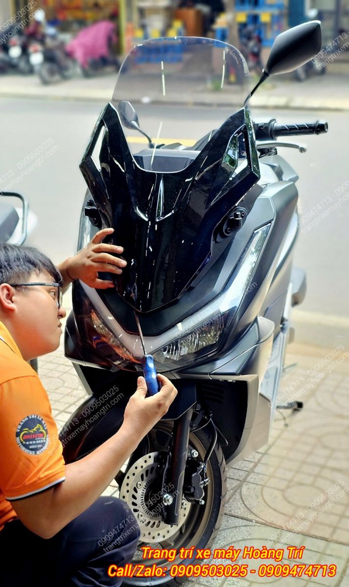 Nhân viên đang tiến hành căn chỉnh và lắp đặt kính chắn gió kiểu Forza 300 cho PCX 160