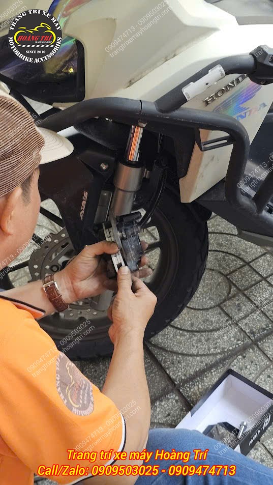 Nhân viên đang lắp đặt má phanh vào heo dầu, giúp xe phanh êm và dừng nhanh chóng hơn