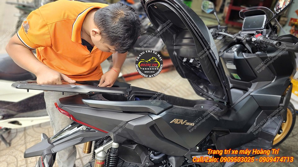 Nhân viên kỹ thuật đang tiến hành lắp baga sau nhôm đúc lên phần đuôi cho Honda ADV 350 màu đen