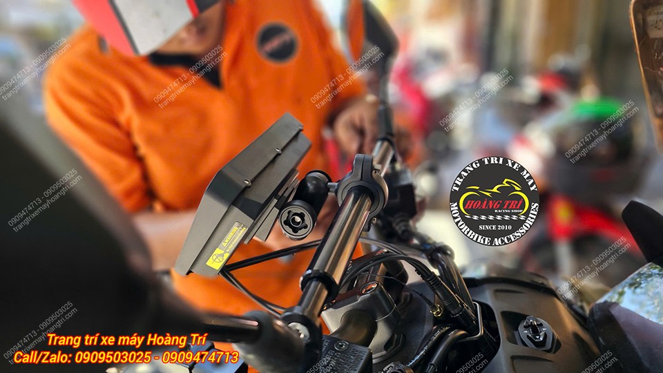 Nhân viên kỹ thuật đang tiến hành lắp màn hình và bộ giá đỡ Android trên vị trí thanh ngang xe