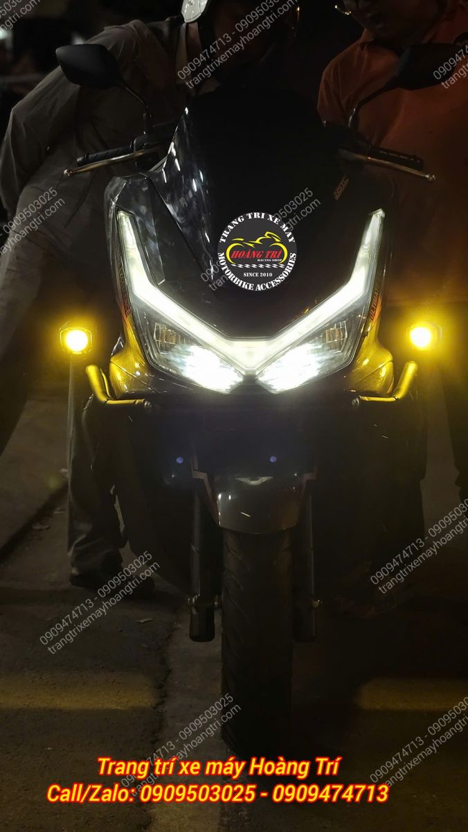 PCX 160 lên đèn với đèn pha xin và đèn trợ sáng vàng nổi bật trên khung bảo vệ tăng an toàn tối đa