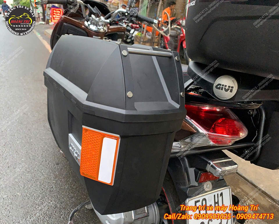 Cận cảnh thùng hông GIVI bên trái có miếng phản quang màu cam nổi bật, tăng tính an toàn và thẩm mỹ