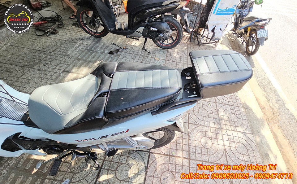 Góc nhìn tổng thể xe Wave 125i 2024 trắng lắp tựa lưng bật gấp V2, tạo điểm nhấn phần đuôi xe
