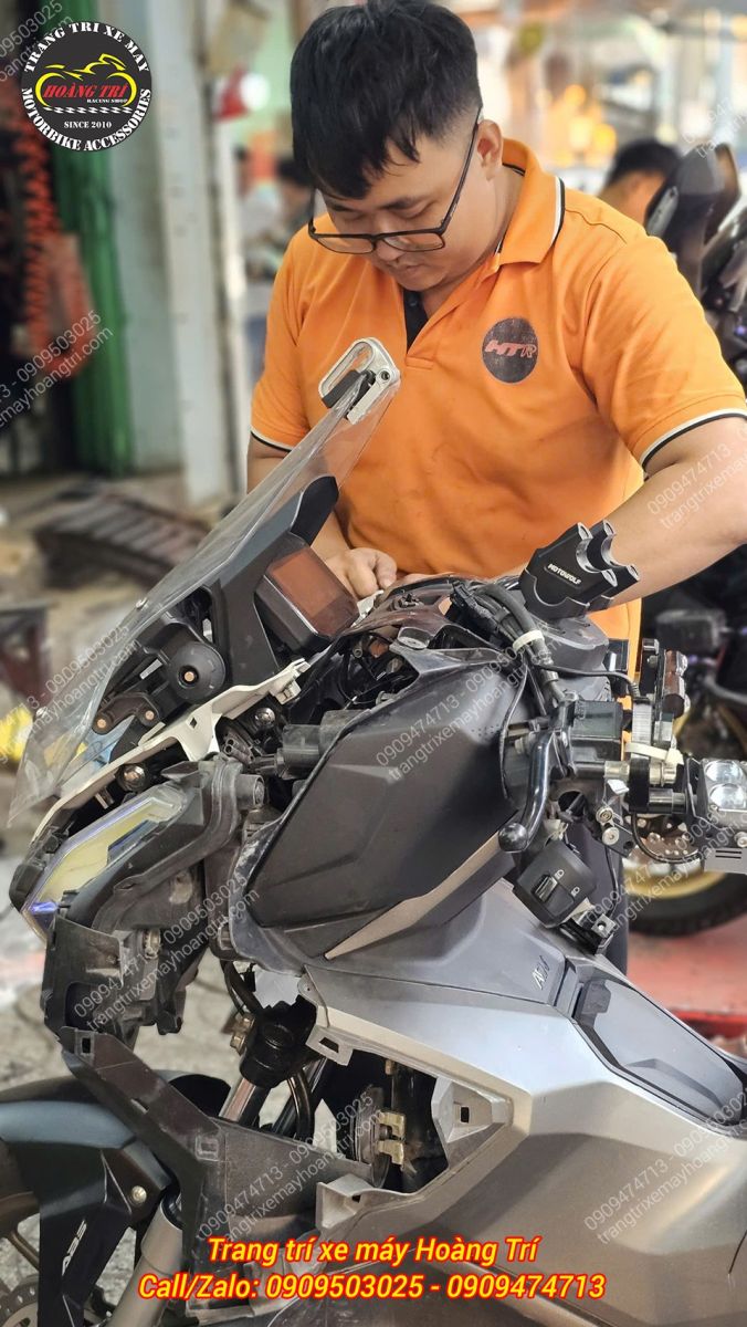 Kỹ thuật viên Hoàng Trí Shop thực hiện lắp đặt gù tay lái LED cho xe ADV 160