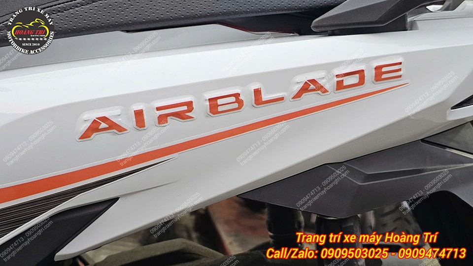 Chi tiết tem chữ Airblade cam nổi bật trên nền decal trắng, tạo điểm nhấn thể thao tinh tế.