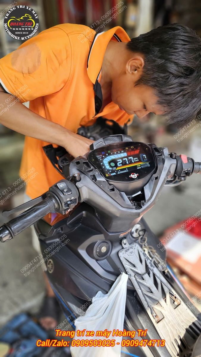 Nhân viên Hoàng Trí Racing Shop thao tác lắp đặt đồng hồ LCD V2 cho Exciter 2019