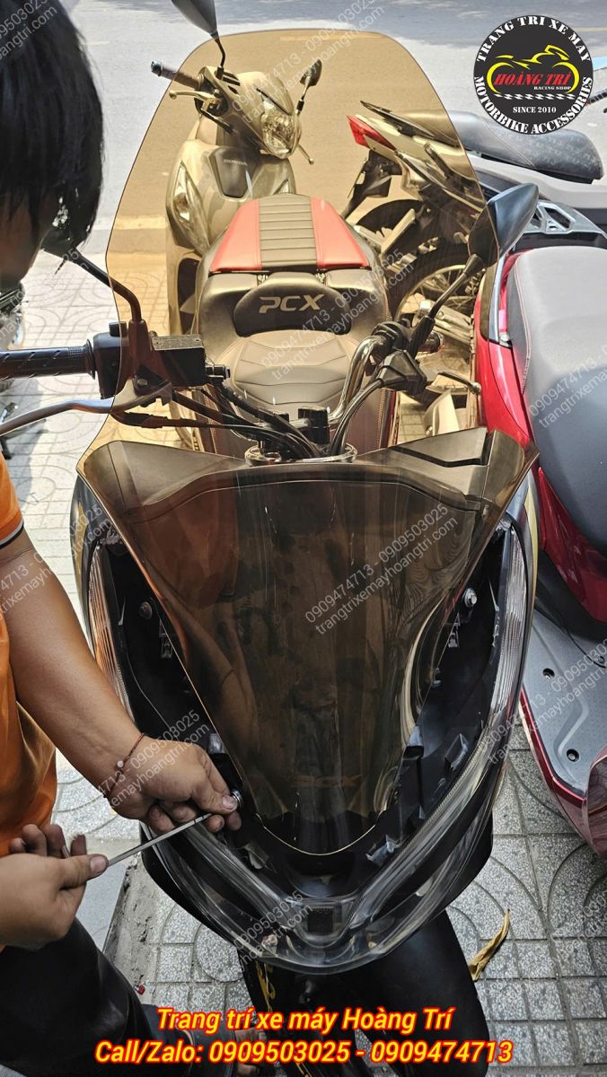 Nhân viên đang lắp đặt kính chắn gió HTR màu trà lắp cho xe PCX 2018