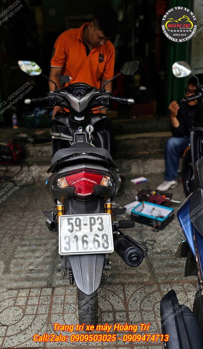 Nhân viên đang trang bị khóa bảo vệ cho chiếc Jupiter của anh khách