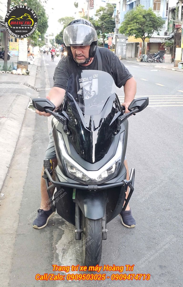 Anh khách chỉnh lại kính hậu gắn trên kính chắn gió Forza 300 NCL