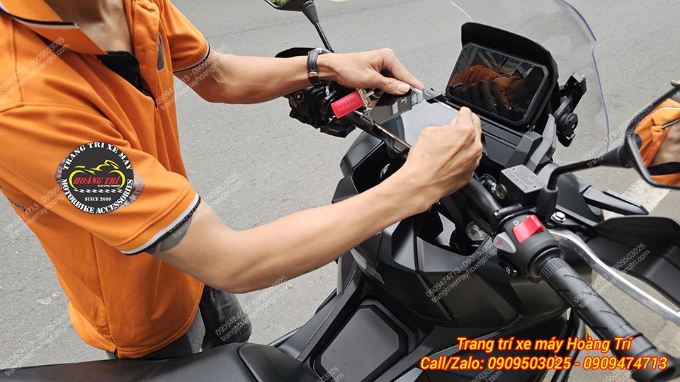 Nhân viên gắn điện thoại lên giá Loboo P02S để kiểm tra sạc