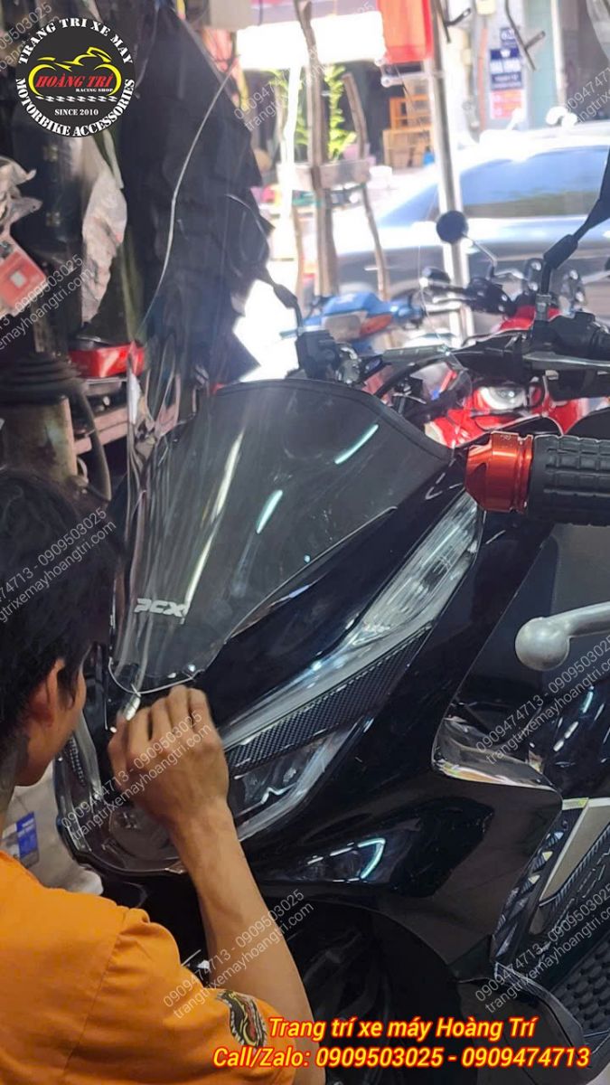 Nhân viên kỹ thuật lắp kính chắn gió HTR cho PCX 2018, đảm bảo chuẩn zin và chắc chắn khi chạy