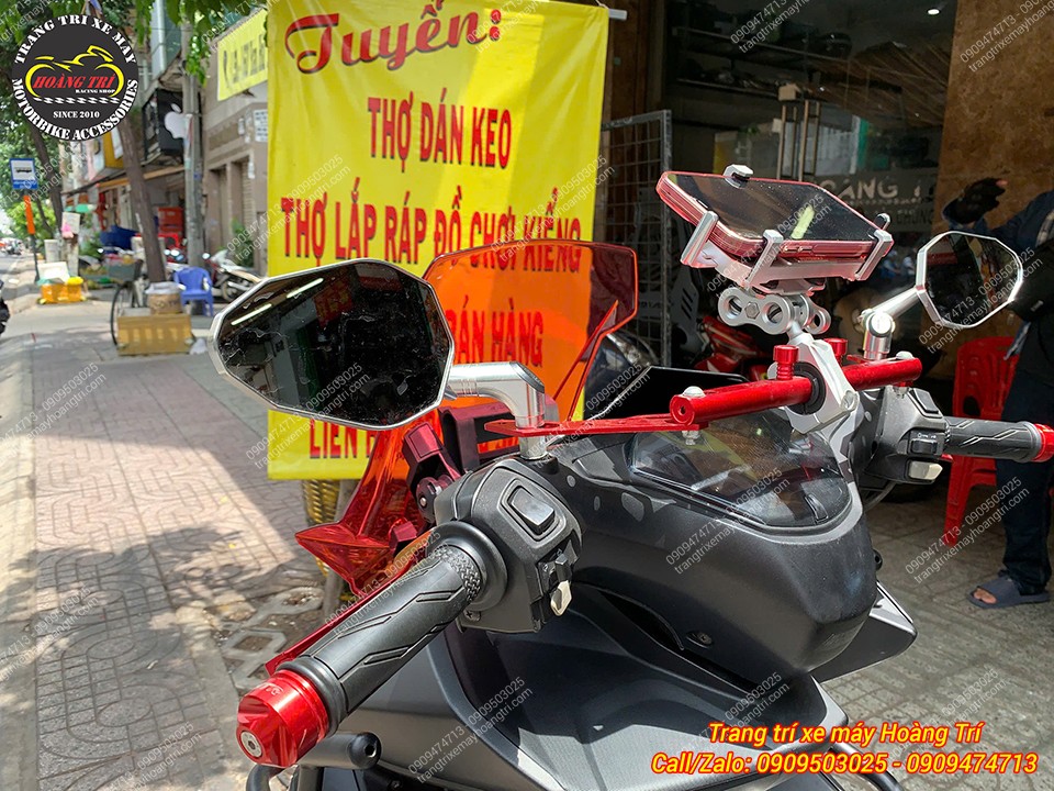 Chi tiết cụm tay lái bên trái với kính chiếu hậu kiểu cùng giá đỡ điện thoại