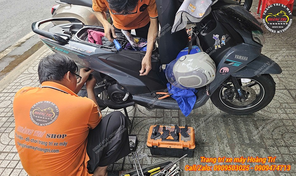 Kỹ thuật viên Hoàng Trí Shop đang tiến hành lắp gác chân phụ HTR cho Yamaha Freego S