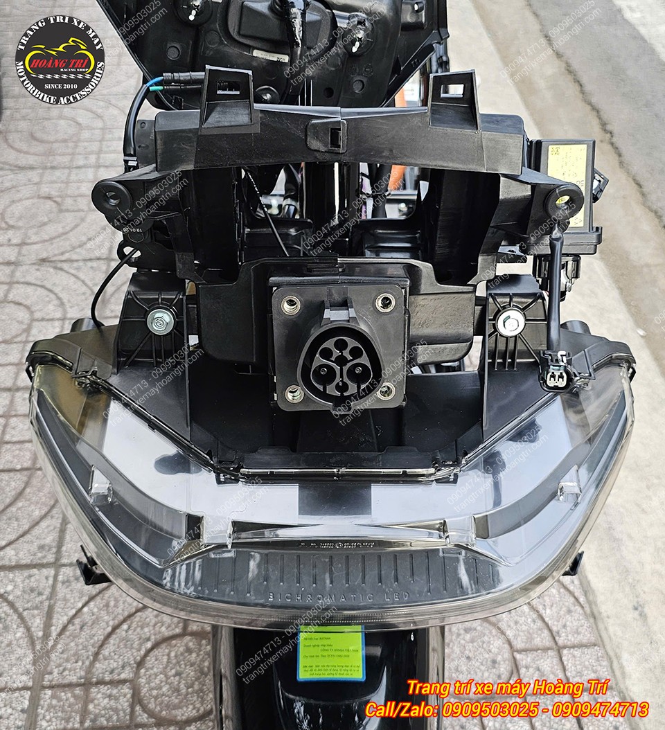 Cụm đèn trước Honda UC3 khi tháo dàn áo để lộ giắc kết nối và khung đỡ
