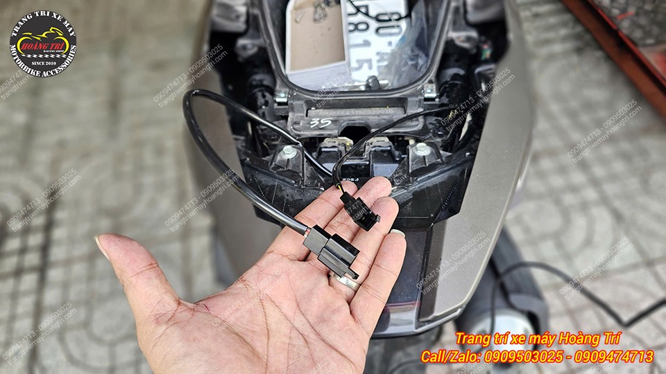 Kỹ thuật viên kết nối hệ thống dây điện cho bộ thùng PCX 160 trong quá trình lắp đặt