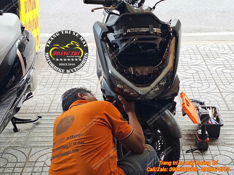 Kỹ thuật viên Hoàng Trí Shop thao tác tháo dàn đầu để xử lý mica đèn PCX 160