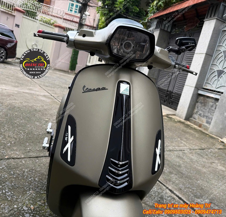 Góc trực diện cho thấy cặp logo chữ X nổi bật cân đối hai bên mặt nạ Vespa Sprint