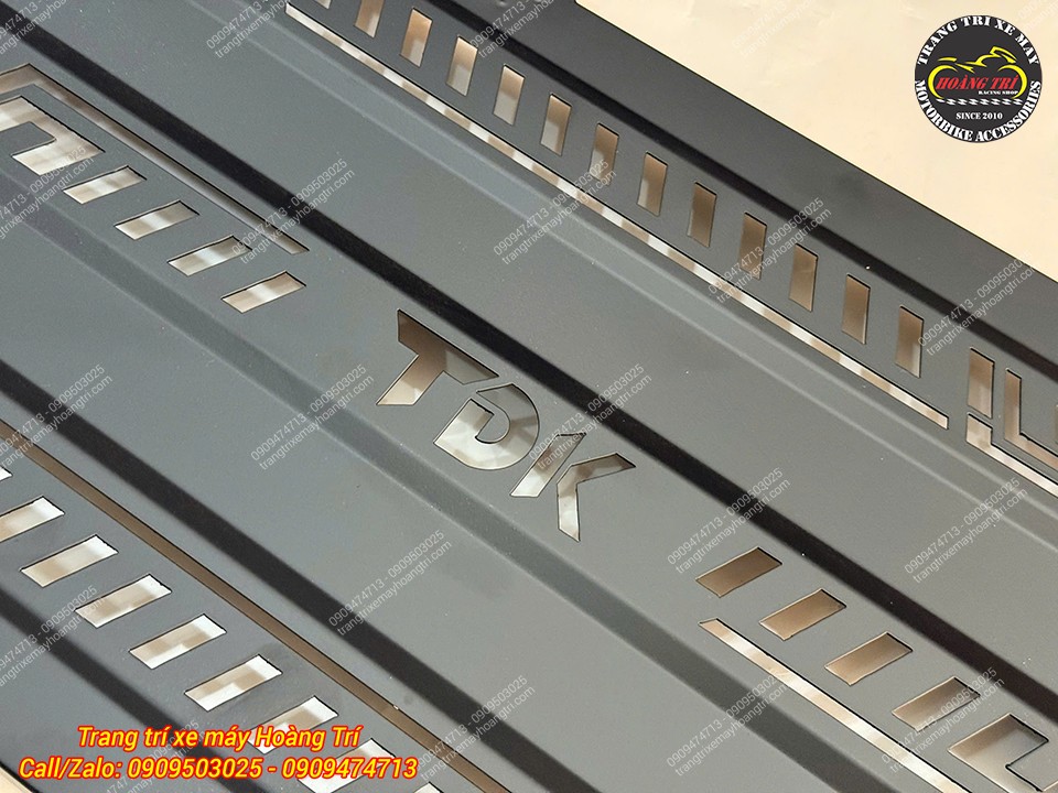 Cận cảnh logo TDK được cắt trên tấm nhôm, kết hợp nhiều khe thoáng bố trí cân đối