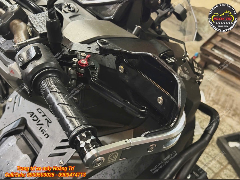 Tay thắng Biker màu đen với núm chỉnh đỏ nổi bật, kết hợp cùng bảo vệ tay lái