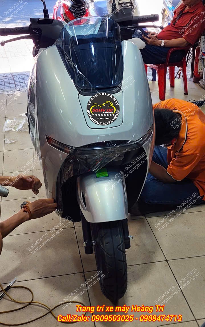 Nhân viên Hoàng Trí Shop đang thi công lớp keo trong suốt tại hai bên đầu Honda UC3