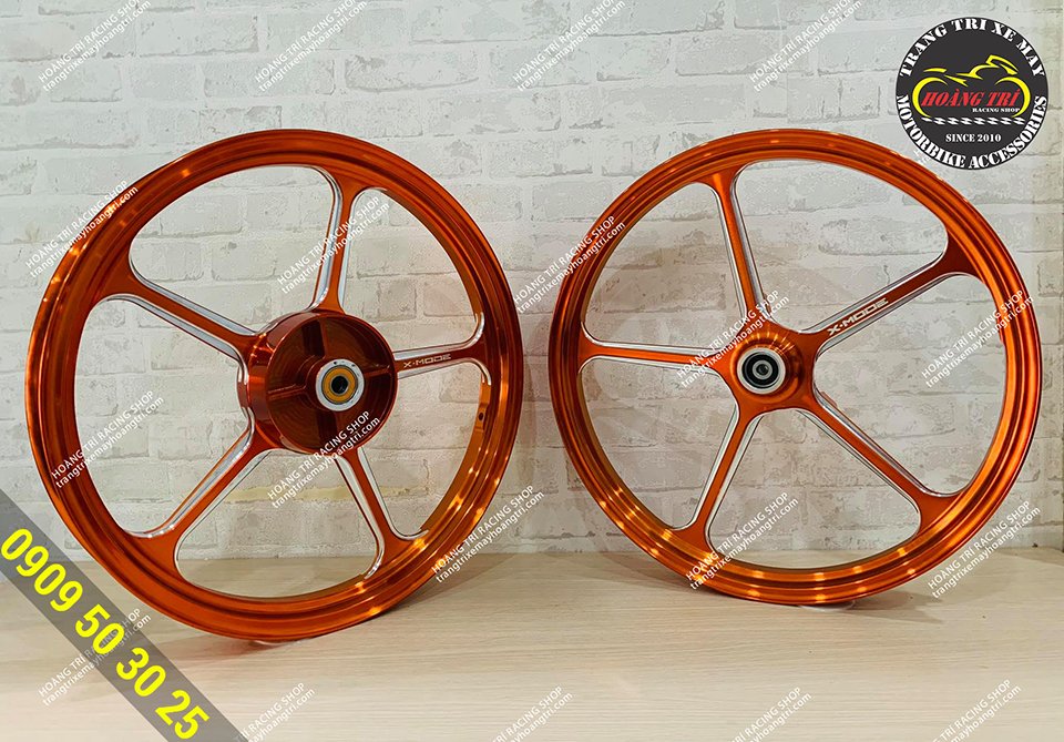 Close-up of orange CNC X Mode aluminum wheels