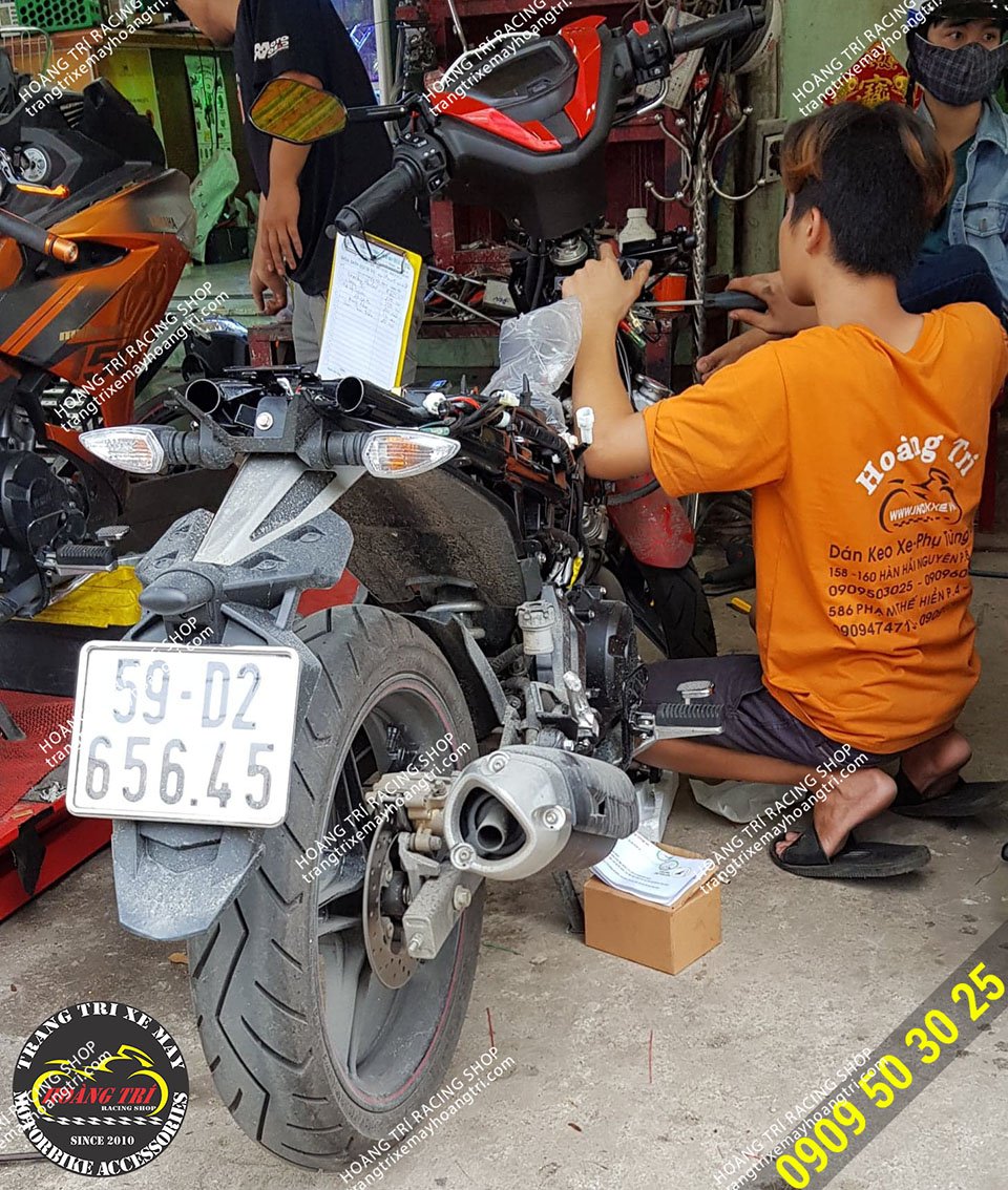 Nhân viên Hoàng Trí Racing Shop đang tháo ổ khóa zin của Exciter 150 2019