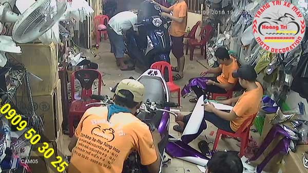 Nhân viên Hoàng Trí Racing Shop đang thi công dán decal crom màu tím cực độc cho Lead 125cc