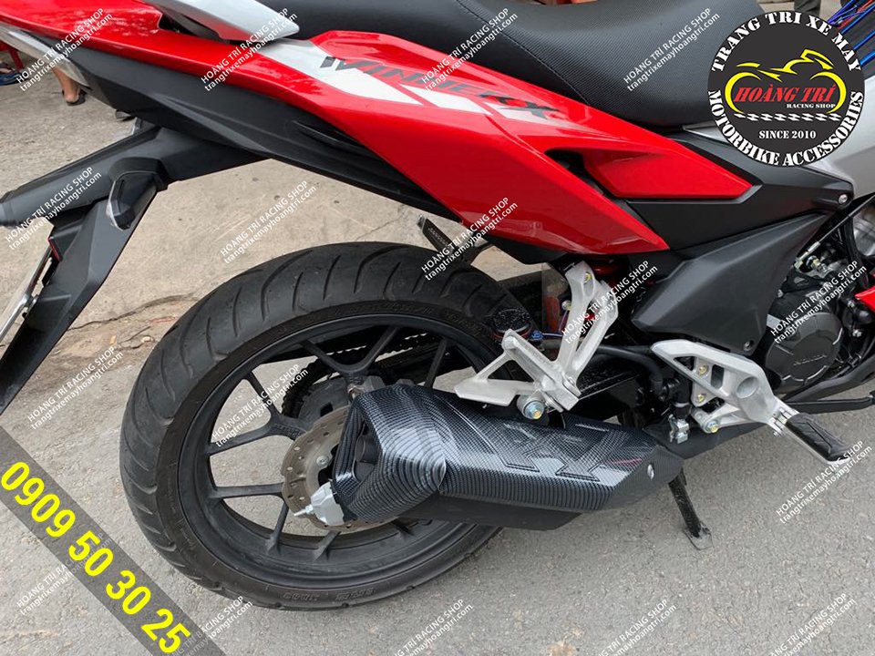 The red Winner X has been fitted with a carbon muffler with the letter W . pattern
